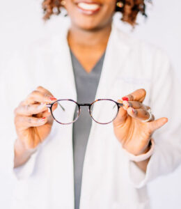 Blurry image of doctor holding glasses as if placing on a face