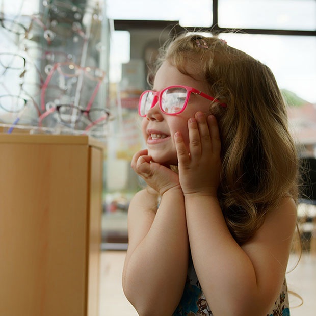 Photo of a child wearing pink glasses and smiling